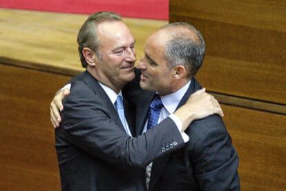 El nuevo presidente de la Generalitat valenciana, Alberto Fabra (izquierda), abraza a su antecesor, Francisco Camps, tras ser investido.