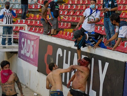 Miembros de la barra del Club Querétaro atacan a un aficionado del Atlas de Guadalajara, el pasado 5 de marzo.