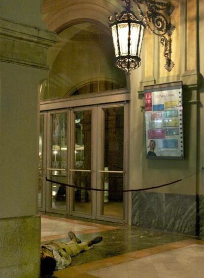 Una persona durmiendo en la entrada del Liceo de Barcelona.