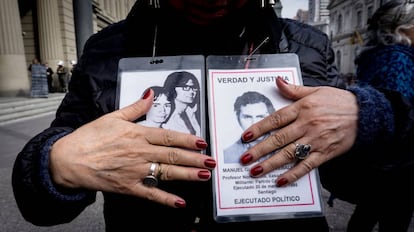 Una activista sostiene fotos de desaparecidos en una protesta frente a la Corte Suprema de Chile.