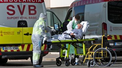 Sanitarios en Urgencias trasladan enfermos desde las ambulancias al Hospital de La Fe de València, que ya ha empezado a derivar pacientes con covid-19 al hospital de campaña..