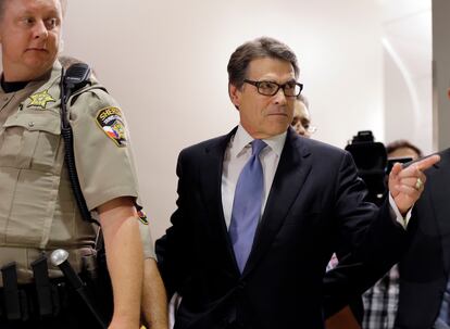 Texas Gov. Rick Perry, right, arrives at the Blackwell Thurman Criminal Justice Center for booking, in Austin, Texas, Aug. 19, 2014