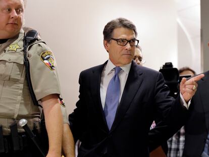 Then-Texas governor Rick Perry, right, arrives at the Blackwell Thurman Criminal Justice Center for booking, in Austin, Texas, August 19, 2014.