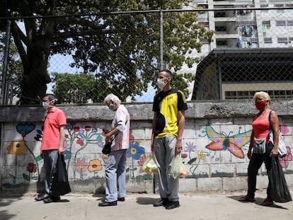 Habitantes de Caracas hace fila para acceder a un mercado de verduras, este jueves.