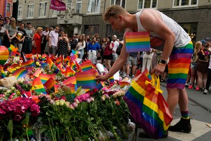 Un joven deposita una bandera arcoiris.