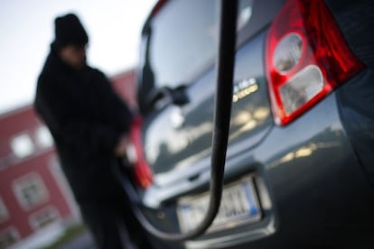 Un hombre llena el dep&oacute;sito de su coche.