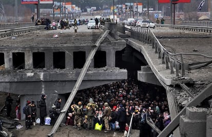 Miles de personas escapaban del asedio ruso a través de un puente destruido entre Irpin y Kiev, el 5 de marzo. “Lo que vemos en Ucrania es horroroso, doloroso, un sufrimiento humano y una escala de violencia como no habíamos visto en Europa desde la II Guerra Mundial”, ha señalado el secretario general de la OTAN, Jens Stoltenberg.