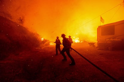 Bomberos rocían agua sobre el incendio Hughes en Castaic, California, el 22 de enero de 2025.