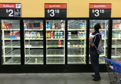 Una mujer observa frigoríficos vacíos en un supermercado, en Houston, Texas.