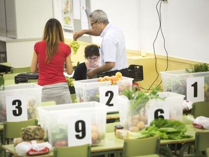 Consumidors d'una cooperativa reparteixen les cistelles.