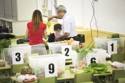 Consumidors d'una cooperativa reparteixen les cistelles.