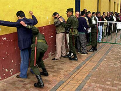 Unos militares colombianos registran a unos votantes antes de entrar en el colegio electoral.