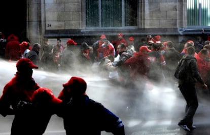 Un grupo de manifestantes en la jornada de protesta contra el Pacto del Euro se enfrenta a los antidisturbios.