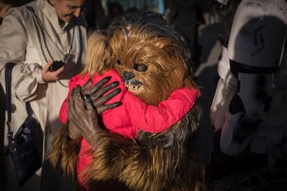 Una persona disfrazada de Chewbacca, personaje de la saga, abraza a una niña en París (Francia).