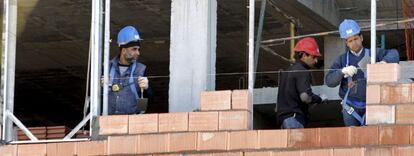 Tres obreros trabajan en la construcci&oacute;n de una vivienda. EFE/Archivo