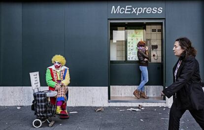 Un hombre, disfrazado de payaso, pidiendo en Cuatro Caminos.