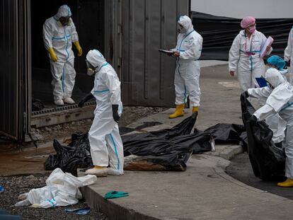 Agentes de criminalística de la Policía Nacional retiran cadáveres en la morgue en Guayaquil, el 12 de junio.