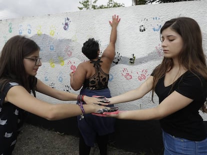 Alunas colocam suas impressões digitais em uma parede na Escola Estadual Raul Brasil, palco de um massacre praticado por dois ex-alunos.