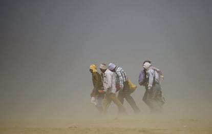 Un grupo de hindúes camina a través de una tormenta de polvo en el Sangam, la mítica confluencia de los ríos Ganges, Yamuna y Saraswati ne Allahabad, India.