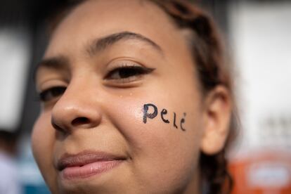 Una seguidora de Pelé en la fila frente al estadio Vila Belmiro, para darle el último adiós durante un velorio hoy, en la ciudad de Santos (Brasil). 
