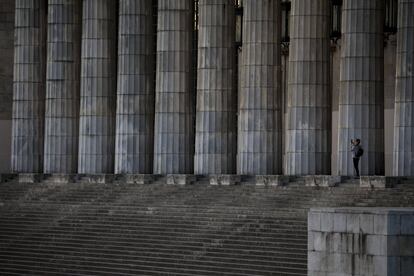 Una mujer hace una foto a la fachada de la Facultad de Derecho de la Universidad de Buenos Aires después de que el Gobierno haya ordenado el estado de emergencia.