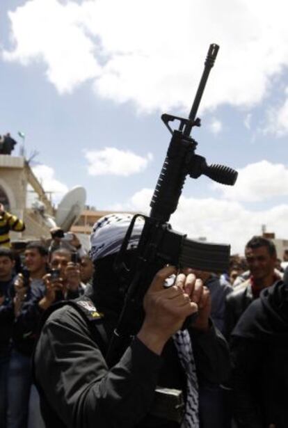 Un palestino, antes de disparar con su arma al aire durante el entierro de Anbu Hamdiyeh.