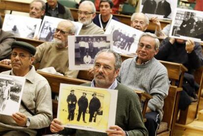 Participantes en el encierro simbólico de apoyo al juez Baltasar Garzón muestran fotografías de represaliados por el franquismo.
