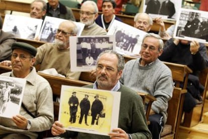 Participantes en el encierro simbólico de apoyo al juez Baltasar Garzón muestran fotografías de represaliados por el franquismo.