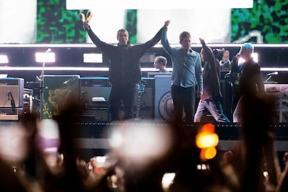 Liam Gallagher, a la izquierda, levanta la mano de Noel Gallagher, durante su concierto de reunión, este viernes en Cardiff.