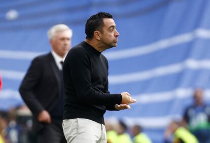 El técnico azulgrana, Xavi, da instrucciones a sus jugadores. Al fondo, Ancelotti, entrenador del Real Madrid.