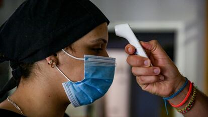 A cooking student has her temperature taken at a restaurant in Madrid.