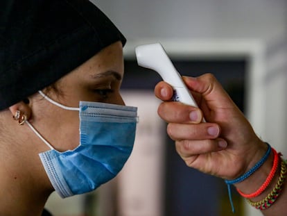 A cooking student has her temperature taken at a restaurant in Madrid.