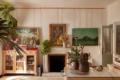 En el salón conviven armónicamente óleos (propios y comprados en el Rastro), muebles de diversas épocas y estilos, una selva de kentias, Ficus lyrata y potos, artesanía popular y libros de arte.