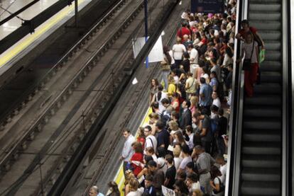 Viajeros esperan en uno de los andenes de la estación de metro de Nuevos Ministerios.