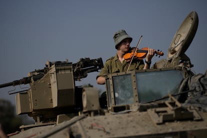 Un soldado israelí toca el violín en un vehículo militar cerca de la frontera con Gaza, este lunes. 