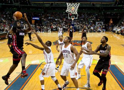 Cuatro jugadores de los Charlotte Bobcats observan como el jugador de Miami LeBron encesta durante el partido