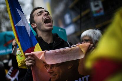 Un manifestante sujeta un cartel con la imagen de Carles Puigdemont durante la protesta en Barcelona, el 25 de marzo de 2018.