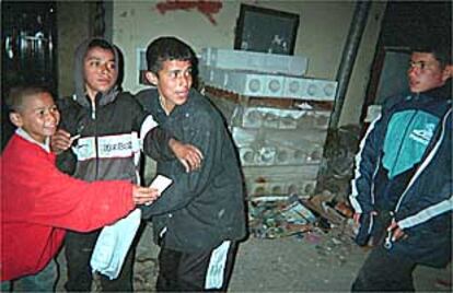 Varios niños de la calle juegan por la noche en las escolleras del puerto de Ceuta.