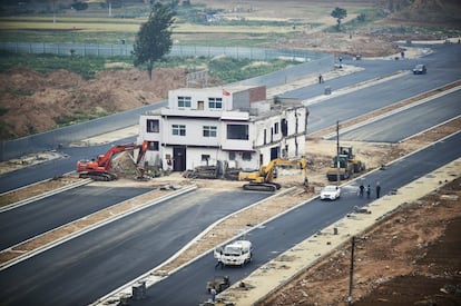 Una 'casa clavo' de tres plantas resiste en mitad de una carretera de Luoyang (en la provincia China de Henan), en una imagen de mayo de 2016. El propietario no alcanzó con las autoriedades un acuerdo de compensación para derribarla