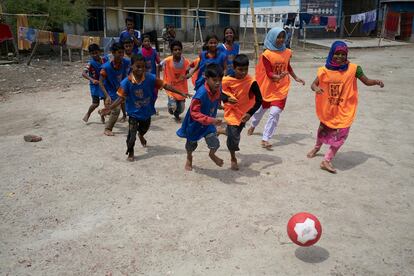 Nupur 
(al fondo, en el centro de la foto) juega 
con sus compañeros al fútbol en un campo improvisado.