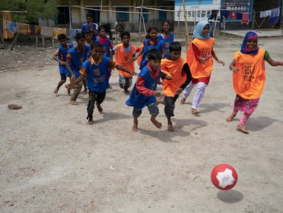 Nupur 
(al fondo, en el centro de la foto) juega 
con sus compañeros al fútbol en un campo improvisado.