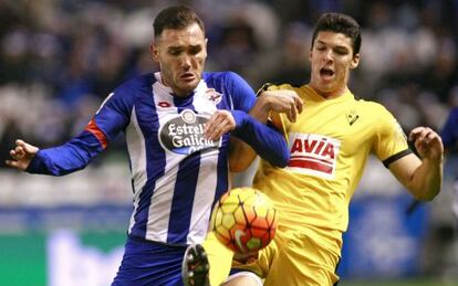 Lucas Pérez (izquierda) disputa un balón con Dos Santos.