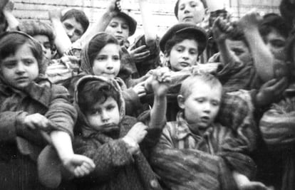 Algunos de los 600 niños supervivientes del campo de concentración de Auschwitz muestran los números de identificación tatuados en sus brazos, el día de su liberación.