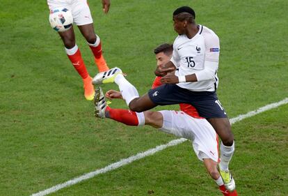 Paul Pogba le disputa el balón al defensa suizo Fabian Schaer.