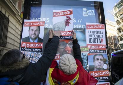 Varias personas colocan carteles contra los dirigentes del 'procés' y Pedro Sánchez en una marquesina cercana a la Tribunal Supremo, en Madrid.