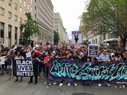 Manifestantes portan carteles con los mensajes "Las vidas de los negros importan" y "Unidos contra el odio".