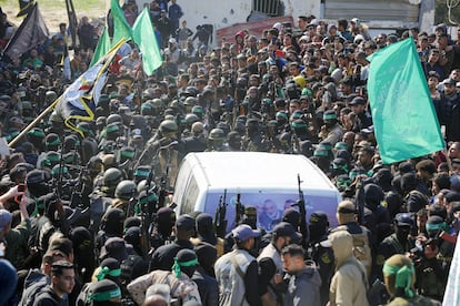 Milicianos armados rodean la convoy con los rehenes israelíes en medio del tumulto. 