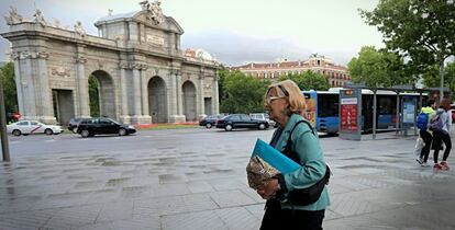 La alcaldesa de Madrid, Manuela Carmena, paseando por Madrid, con la Puerta de Alcalá de fondo.