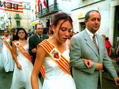 La 'pubilla' de Santa Bàrbara sorbe las lágrimas mientras desfila del brazo de Felip Puig.