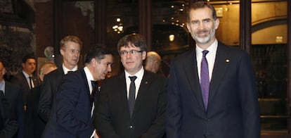 El rey Felipe VI junto al presidente de la Generalitat, Carles Puigdemont, a su llegada a la cena de bienvenida a los asistentes al Mobile World Congress (MWC), en el Palau de la M&uacute;sica.